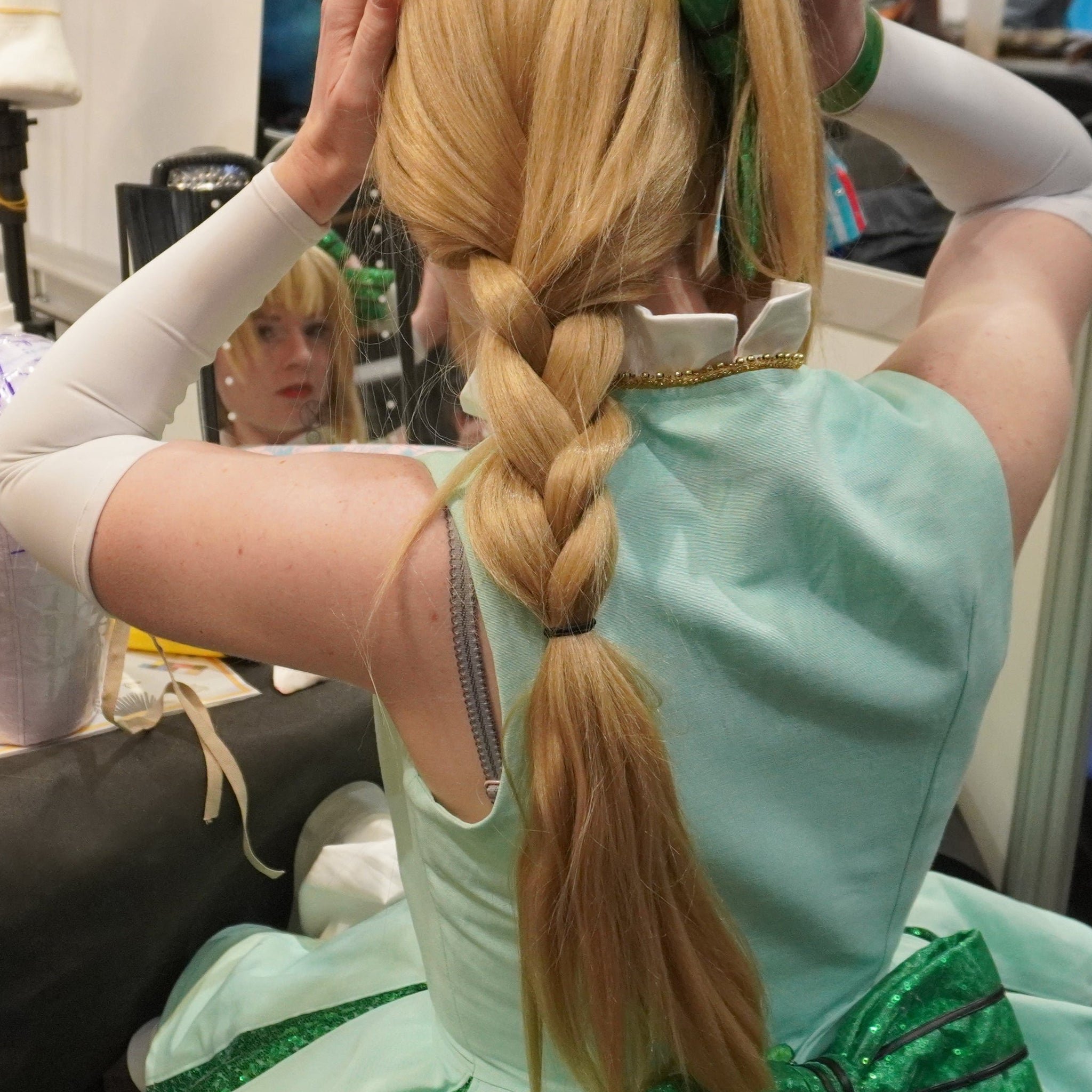 cosplayeuse en train de remettre sa perruque sur le stand makeup 
