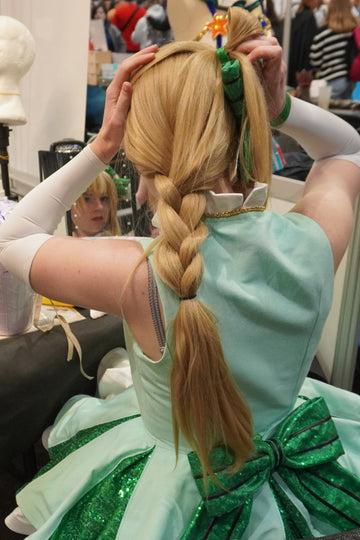 cosplayeuse en train de remettre sa perruque sur le stand makeup 